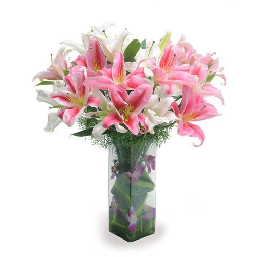 10 Oriental Lilies With Some Orchid Petals And Green Leaves In A Glass Vase